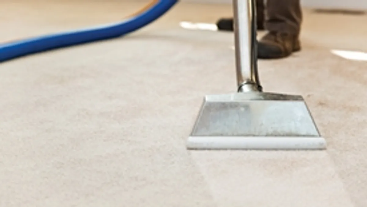 Carpet cleaning wand head gliding over a light carpet during hot-water extraction, New Orleans, LA.